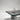 Aayutha monolithic dining table by Magari, featuring a low seating design with a black matte finish and a rough-cut natural grey granite texture, blending robust materials with elegant design.
