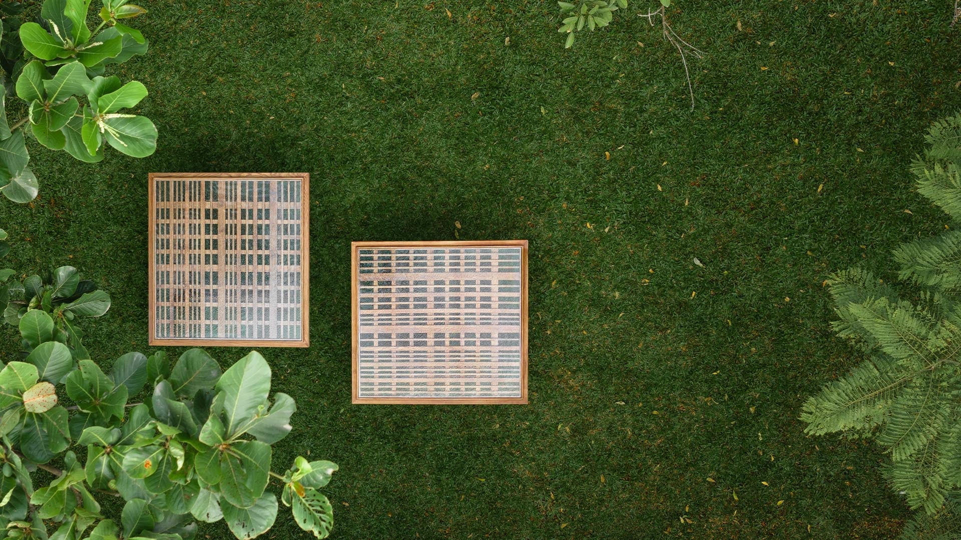 A top view of two Ibbani Side Tables from the Magari x AAD Collection, showcasing a slatted wood base topped with fused glass, creating a sculptural contrast.